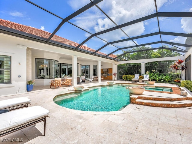 view of swimming pool featuring outdoor dry bar, a patio area, a lanai, and a pool with connected hot tub