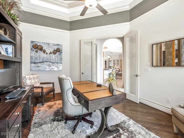 office space featuring arched walkways, a ceiling fan, baseboards, dark wood finished floors, and crown molding