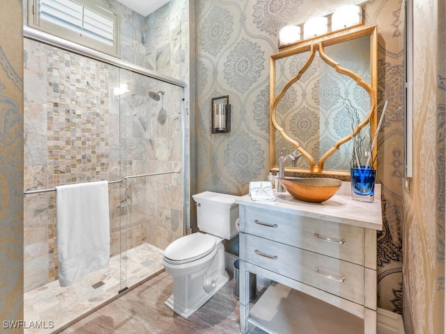 full bath with a stall shower, vanity, toilet, and wallpapered walls