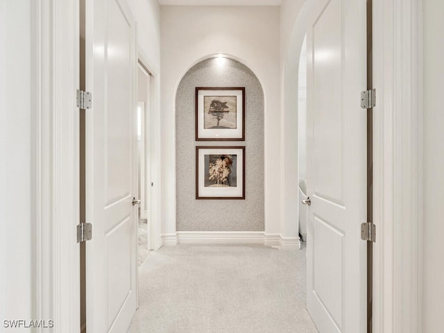 corridor with light carpet and baseboards