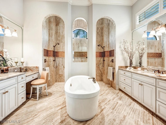 full bathroom featuring two vanities, ornamental molding, a sink, a walk in shower, and a freestanding tub