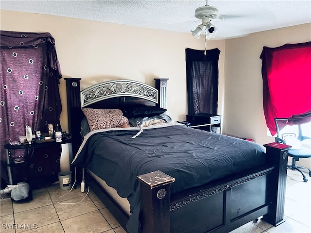 tiled bedroom with ceiling fan and a textured ceiling