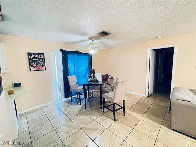 dining room with ceiling fan, a textured ceiling, and light tile patterned floors