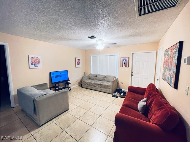 living room featuring ceiling fan, a textured ceiling, and light tile patterned floors