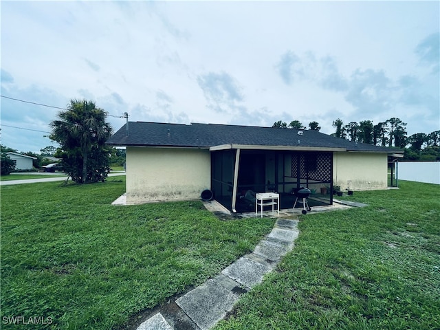 rear view of property with a patio and a yard