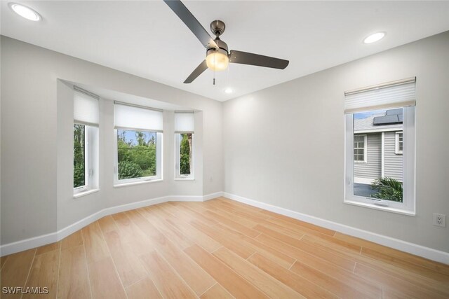 empty room featuring a healthy amount of sunlight, light wood-type flooring, baseboards, and recessed lighting