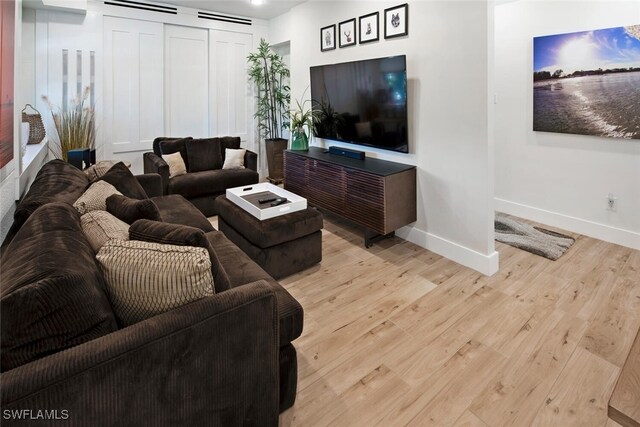 living area featuring light wood finished floors and baseboards