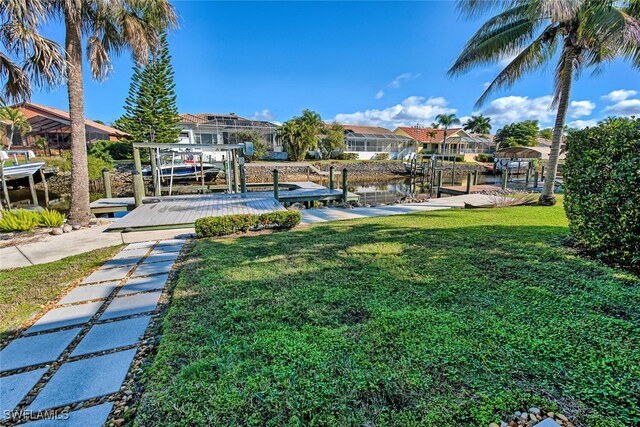 exterior space featuring a residential view, a lawn, boat lift, and a boat dock