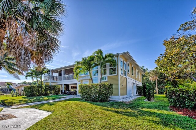 exterior space with a balcony, a yard, and a garage