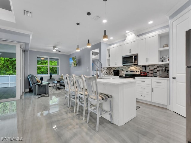 kitchen featuring pendant lighting, open shelves, appliances with stainless steel finishes, a kitchen island with sink, and white cabinetry