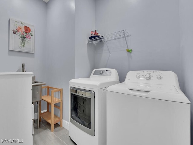 washroom featuring laundry area, baseboards, and independent washer and dryer