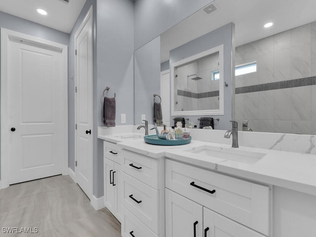 bathroom with double vanity, walk in shower, a sink, and visible vents