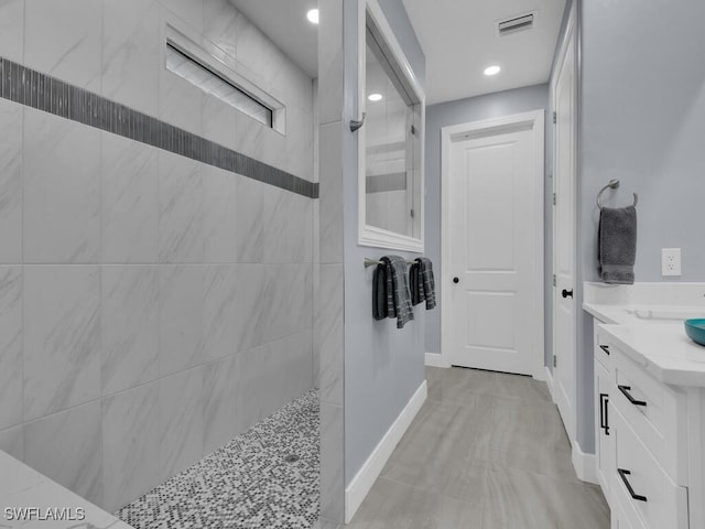 bathroom with baseboards, visible vents, vanity, a walk in shower, and recessed lighting