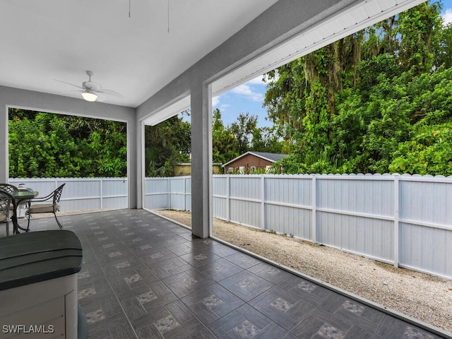 unfurnished sunroom with ceiling fan