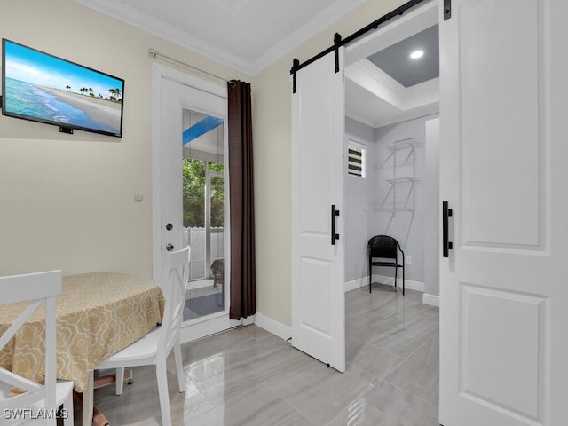 foyer featuring baseboards, a barn door, and crown molding