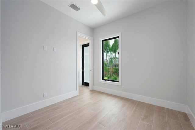 spare room with visible vents, baseboards, light wood-style flooring, and a ceiling fan