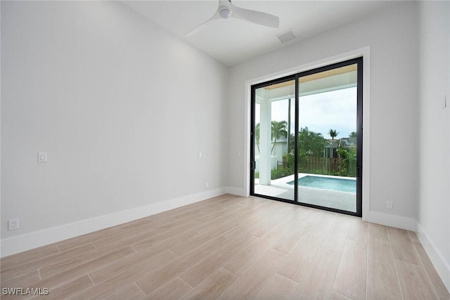 spare room with light wood finished floors, visible vents, baseboards, and ceiling fan