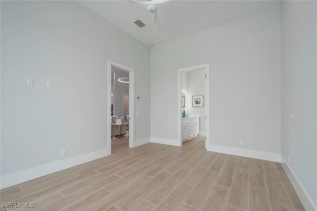 empty room with visible vents, baseboards, light wood-style floors, and a ceiling fan