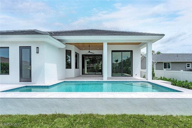 rear view of property featuring a patio area, a fenced in pool, stucco siding, and fence