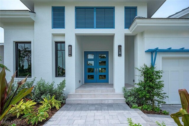 entrance to property featuring a garage and french doors