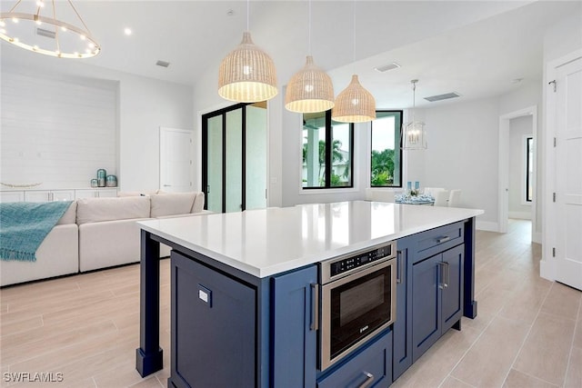 kitchen featuring visible vents, open floor plan, light countertops, an inviting chandelier, and blue cabinets