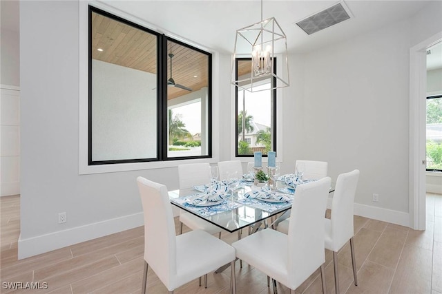 dining room with an inviting chandelier, light wood-style flooring, visible vents, and baseboards