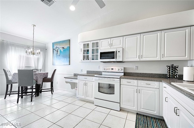 kitchen featuring white cabinets, light tile patterned floors, pendant lighting, and white appliances