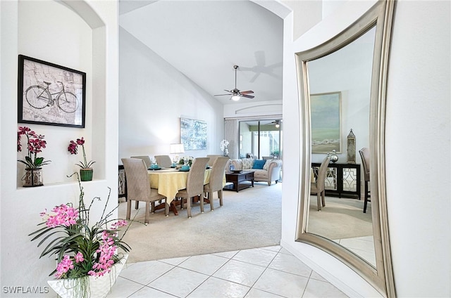 dining room featuring light colored carpet, high vaulted ceiling, and ceiling fan