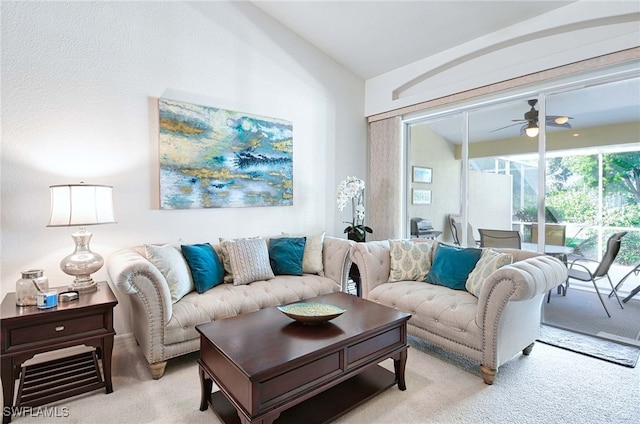 carpeted living room featuring ceiling fan and vaulted ceiling