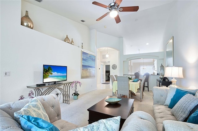 carpeted living room featuring ceiling fan and high vaulted ceiling