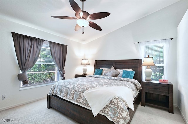 bedroom with ceiling fan, lofted ceiling, and light colored carpet