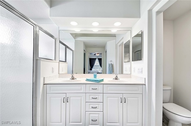 bathroom featuring vanity, a shower with shower door, and toilet