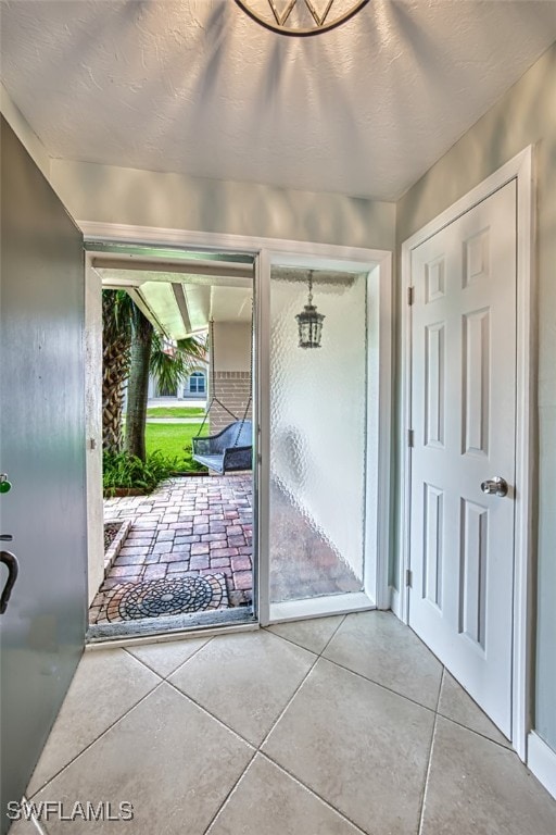 doorway featuring a textured ceiling and tile patterned floors