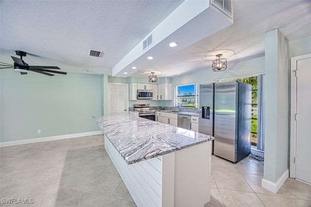 kitchen featuring light tile patterned floors, stainless steel appliances, light stone countertops, ceiling fan, and white cabinets