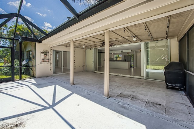 view of patio featuring a lanai