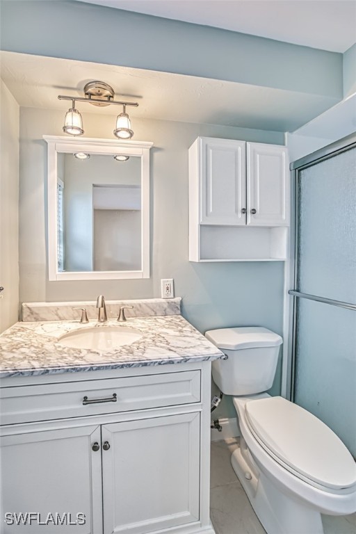 full bathroom featuring toilet, an enclosed shower, and vanity