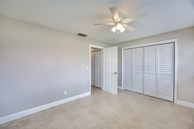 unfurnished bedroom featuring ceiling fan, a closet, and light tile patterned floors