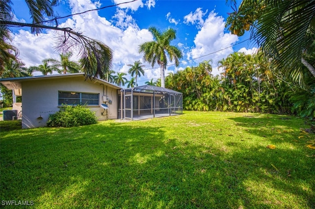 view of yard with central AC and a lanai