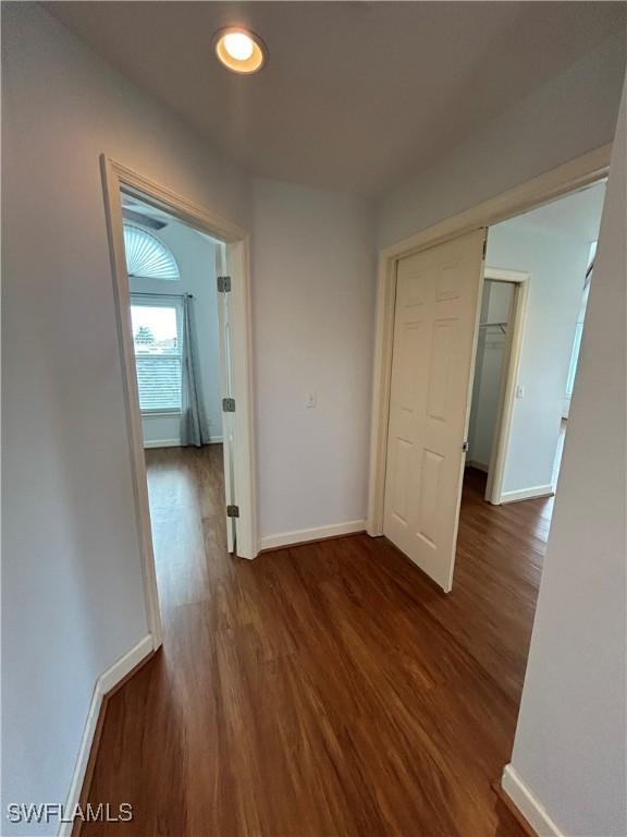 hall with dark wood finished floors and baseboards