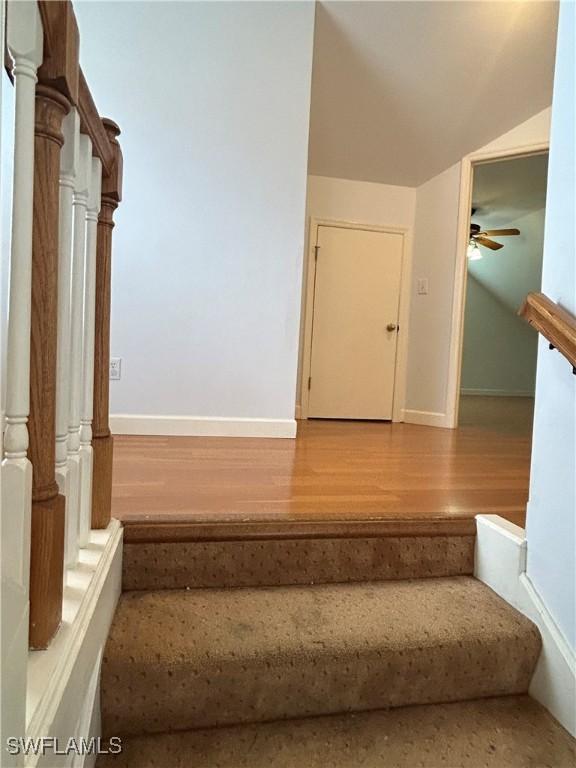 staircase featuring hardwood / wood-style floors, ornate columns, and ceiling fan