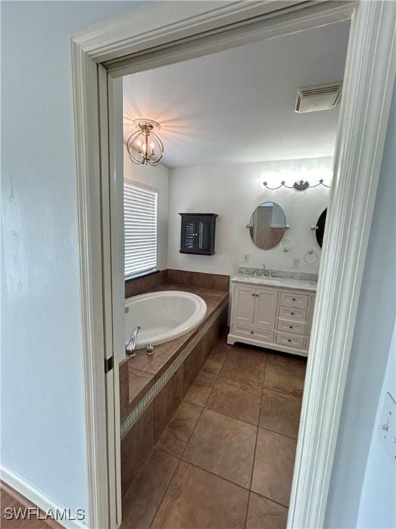 bathroom with a garden tub, tile patterned flooring, vanity, visible vents, and an inviting chandelier