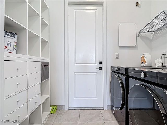 laundry room featuring light tile patterned flooring and washing machine and clothes dryer