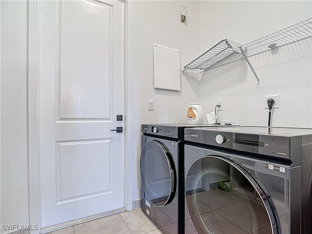 washroom with light tile patterned floors, laundry area, and separate washer and dryer