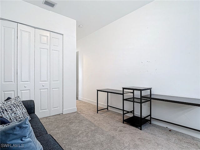 interior space with baseboards, visible vents, and light colored carpet