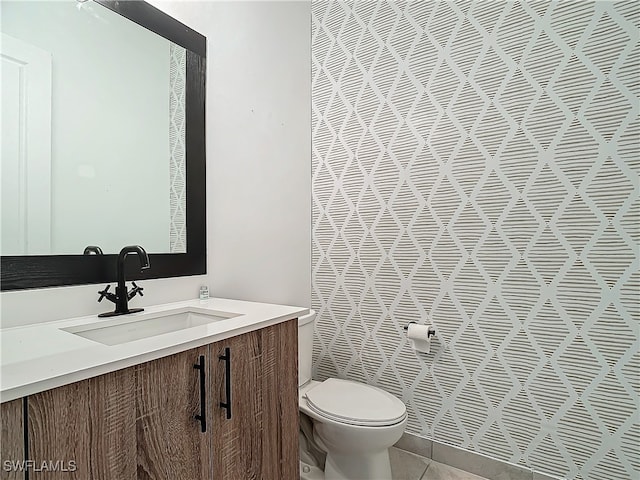 bathroom with tile patterned flooring, vanity, and toilet