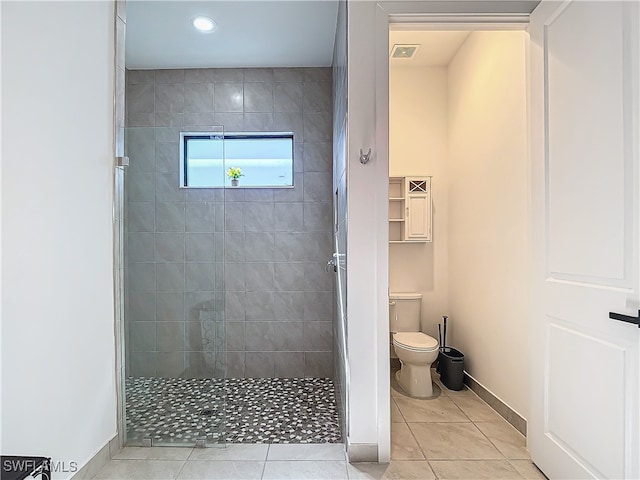 bathroom with tile patterned floors, visible vents, toilet, baseboards, and walk in shower