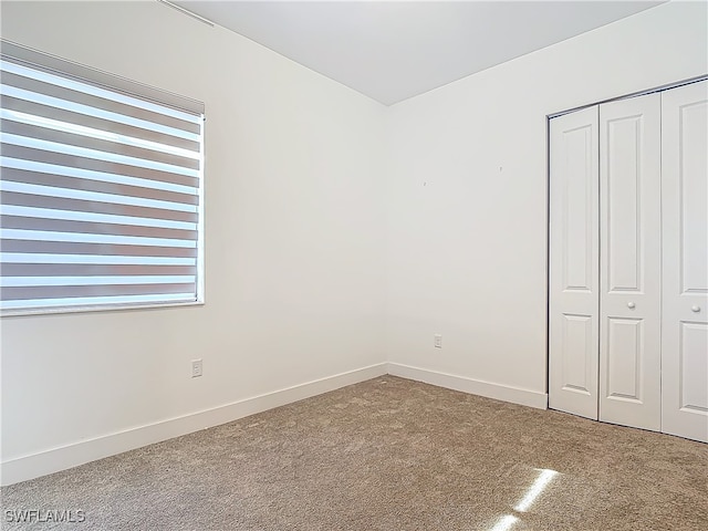 unfurnished bedroom with carpet flooring and a closet