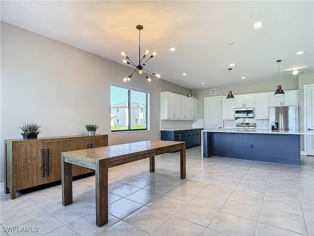 kitchen featuring pendant lighting, white cabinets, a center island with sink, and appliances with stainless steel finishes