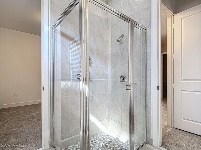 bathroom with a stall shower and baseboards