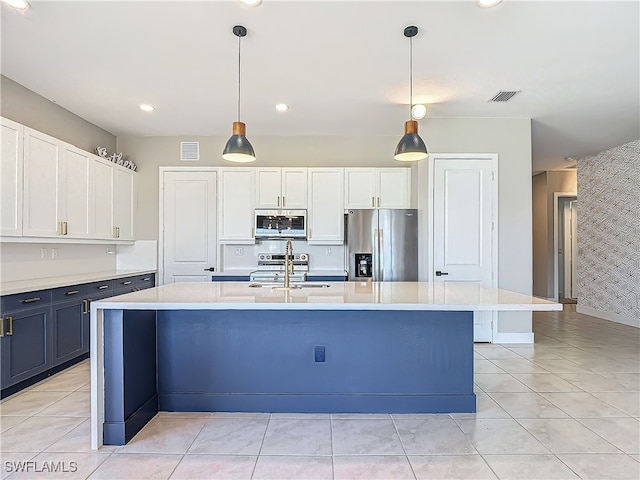 kitchen with an island with sink, a sink, stainless steel appliances, and light countertops